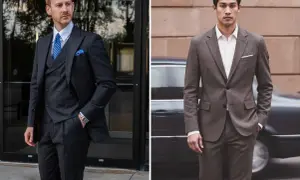 Uomo con abito grigio, gilet e cravatta blu. Accanto, un altro uomo con abito grigio e cravatta.