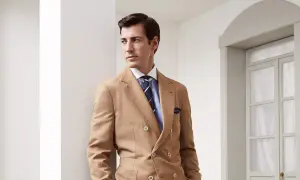 Uomo elegante con abito doppiopetto color cammello e cravatte ultima moda a righe blu.