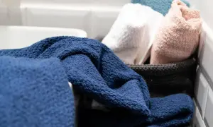 Asciugamani blu, bianchi, rosa e azzurri pronti per essere lavati a 90 gradi per una pulizia profonda.