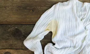Maglione bianco con evidenti macchie gialle sotto l'ascella, un problema comune per chi cerca come togliere macchie di sudore vecchie.