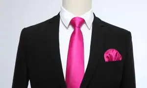 Un completo nero con camicia bianca, una cravatta rosa acceso e un fazzoletto da taschino coordinato. Un abbinamento audace e di classe.