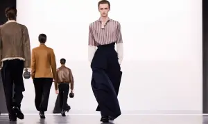 Sfilata di moda maschile: un modello indossa pantaloni ampi blu scuro. Taglia 16 a cosa corrisponde?