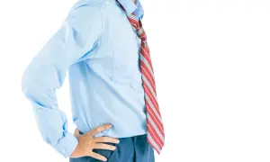 Uomo con camicia azzurra e cravatta a righe rosse, gialle e bianche. La lunghezza cravatta è visibile, arrivando appena sotto la cintura.