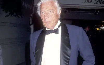 Gianni Agnelli con cravatta a farfalla e giacca elegante, un'icona di stile.