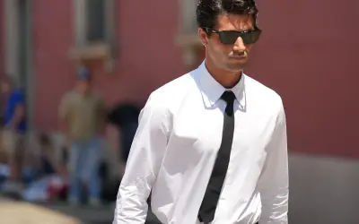 Uomo con camicia bianca e cravatta nera, un esempio di stile con colletti per camicie da uomo impeccabili.