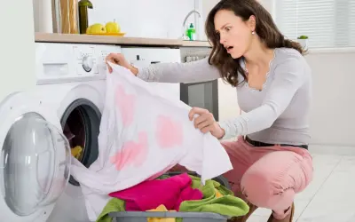 Donna sorpresa scopre macchie scure sui vestiti dopo lavaggio in lavatrice. Come toglierle?