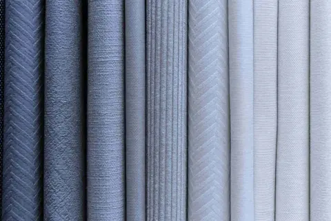 Varietà di tessuti con diverse trame e fantasie, che ricordano i diversi tipi di camicie: dal rigato al chevron, dal puntinato al liscio.