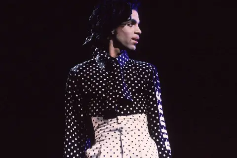 Iconico Prince con camicia a pois uomo e pantaloni a vita alta, un look audace e indimenticabile.