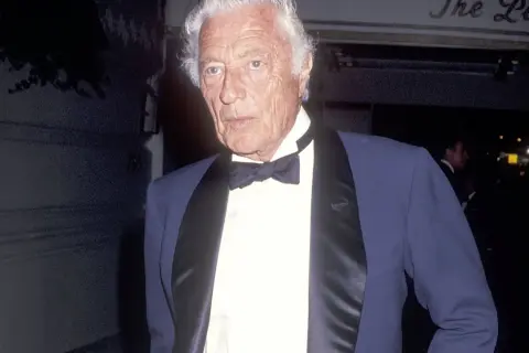 Gianni Agnelli con cravatta a farfalla e giacca elegante, un'icona di stile.