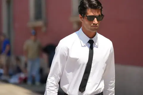 Uomo con camicia bianca e cravatta nera, un esempio di stile con colletti per camicie da uomo impeccabili.