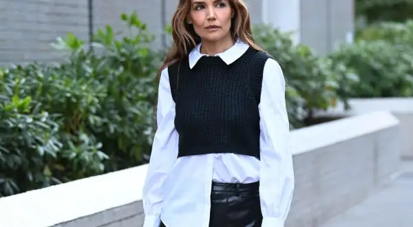 Donna con camicia bianca e gilet nero, la camicia si mette dentro o fuori, con gonna in pelle.