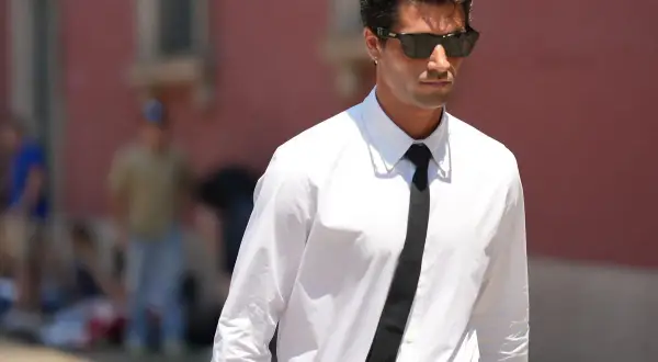 Uomo con camicia bianca e cravatta nera, un esempio di stile con colletti per camicie da uomo impeccabili.