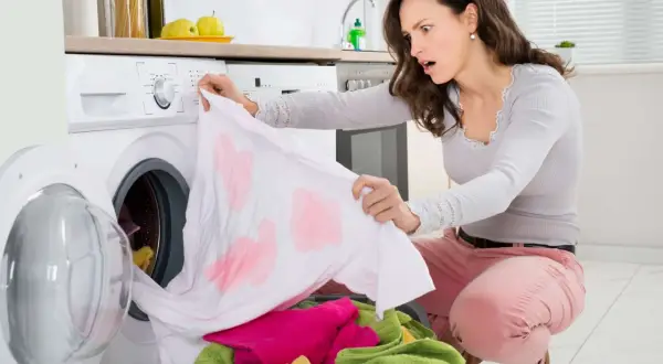 Donna sorpresa scopre macchie scure sui vestiti dopo lavaggio in lavatrice. Come toglierle?
