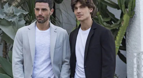Due uomini con giacca blu e jeans, un look casual chic perfetto per ogni occasione.