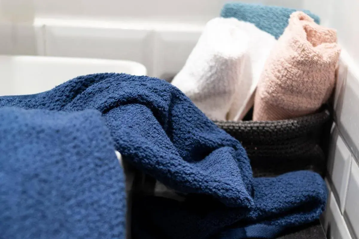 Asciugamani blu, bianchi, rosa e azzurri pronti per essere lavati a 90 gradi per una pulizia profonda.