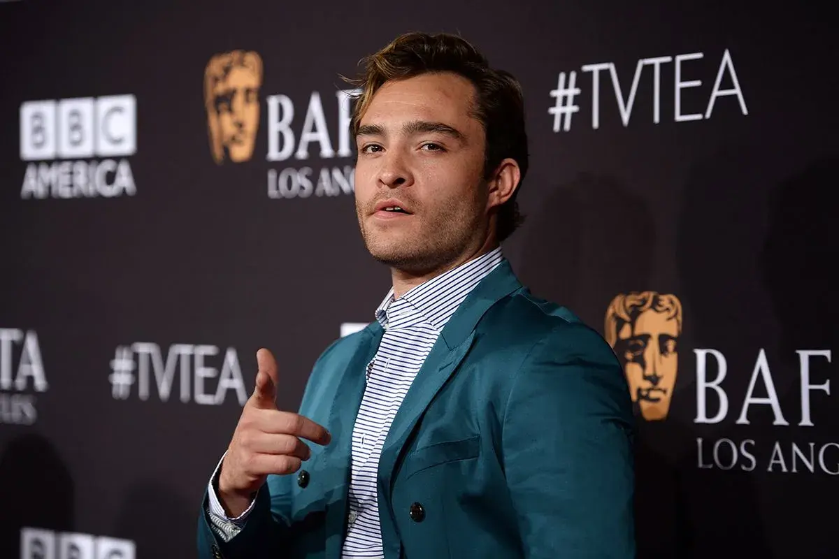 Ed Westwick con giacca color ottanio, un esempio di come abbinare il color ottanio abbigliamento con camicia a righe.