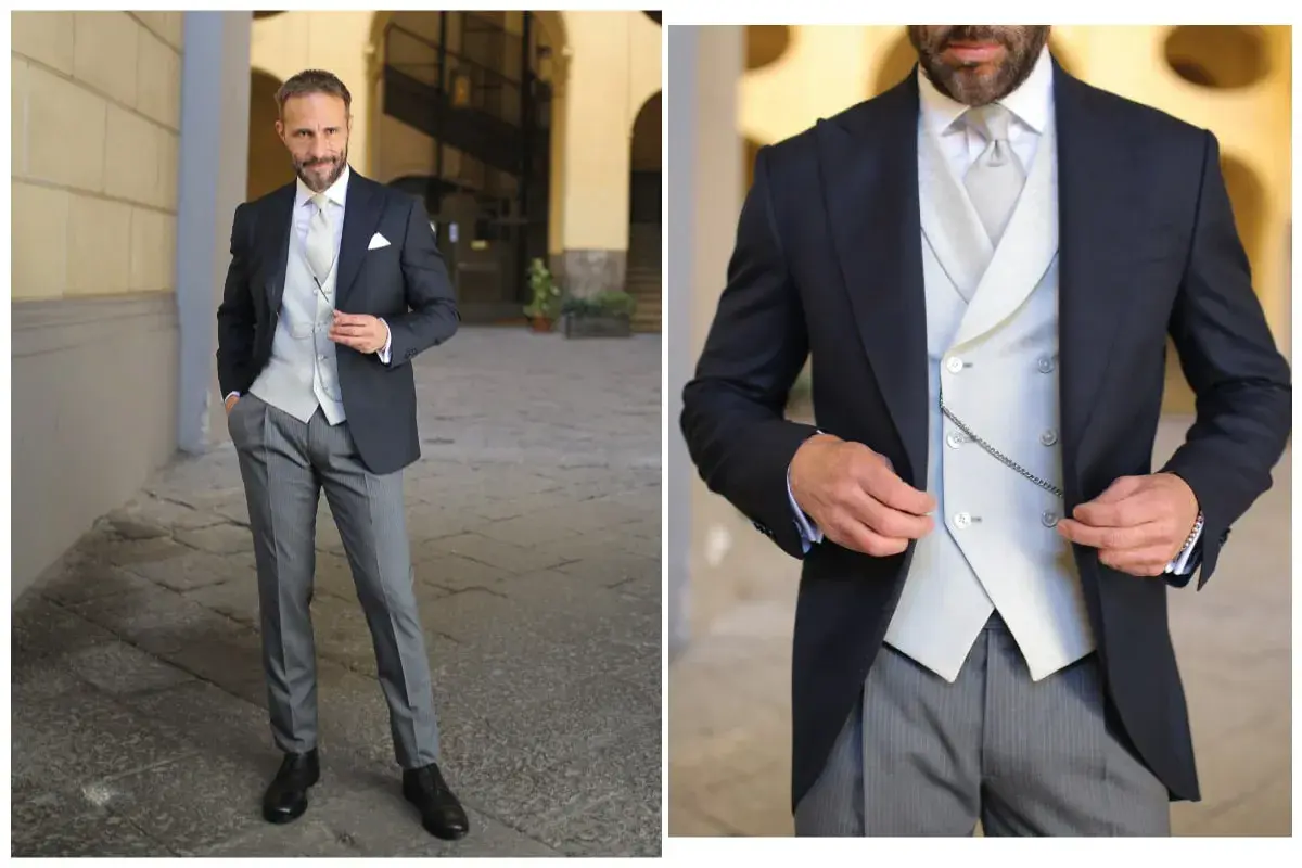 Uomo elegante in spezzato con cravatta, gilet e catenella da orologio.