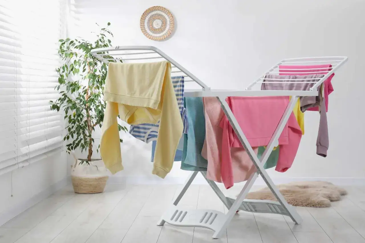 Stendibiancheria con panni colorati, un modo pratico per capire come asciugare i pantaloni velocemente fuori casa.