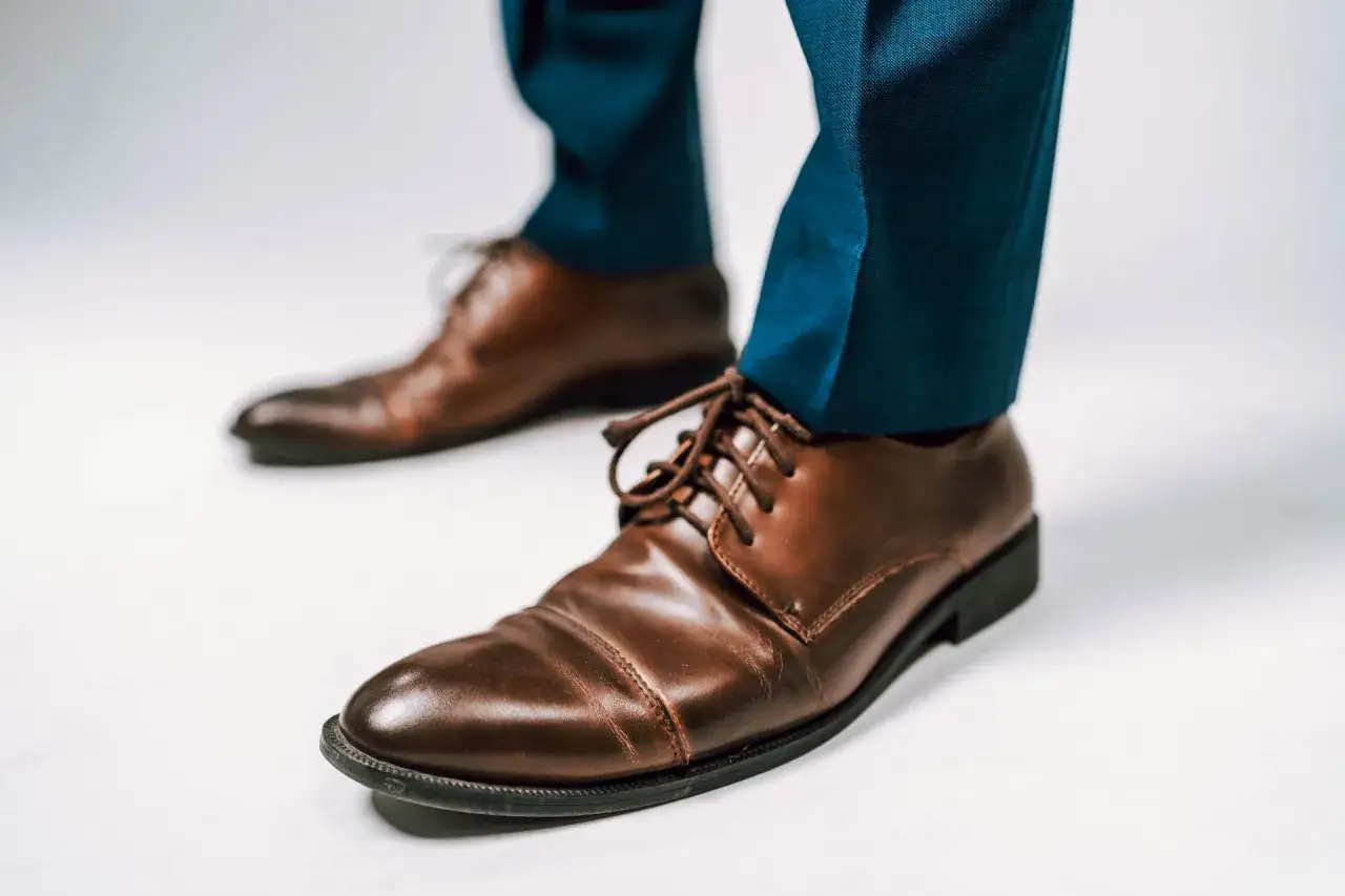 Scarpe stringate color cuoio con pantaloni blu. Un classico per abbinamenti eleganti e raffinati.