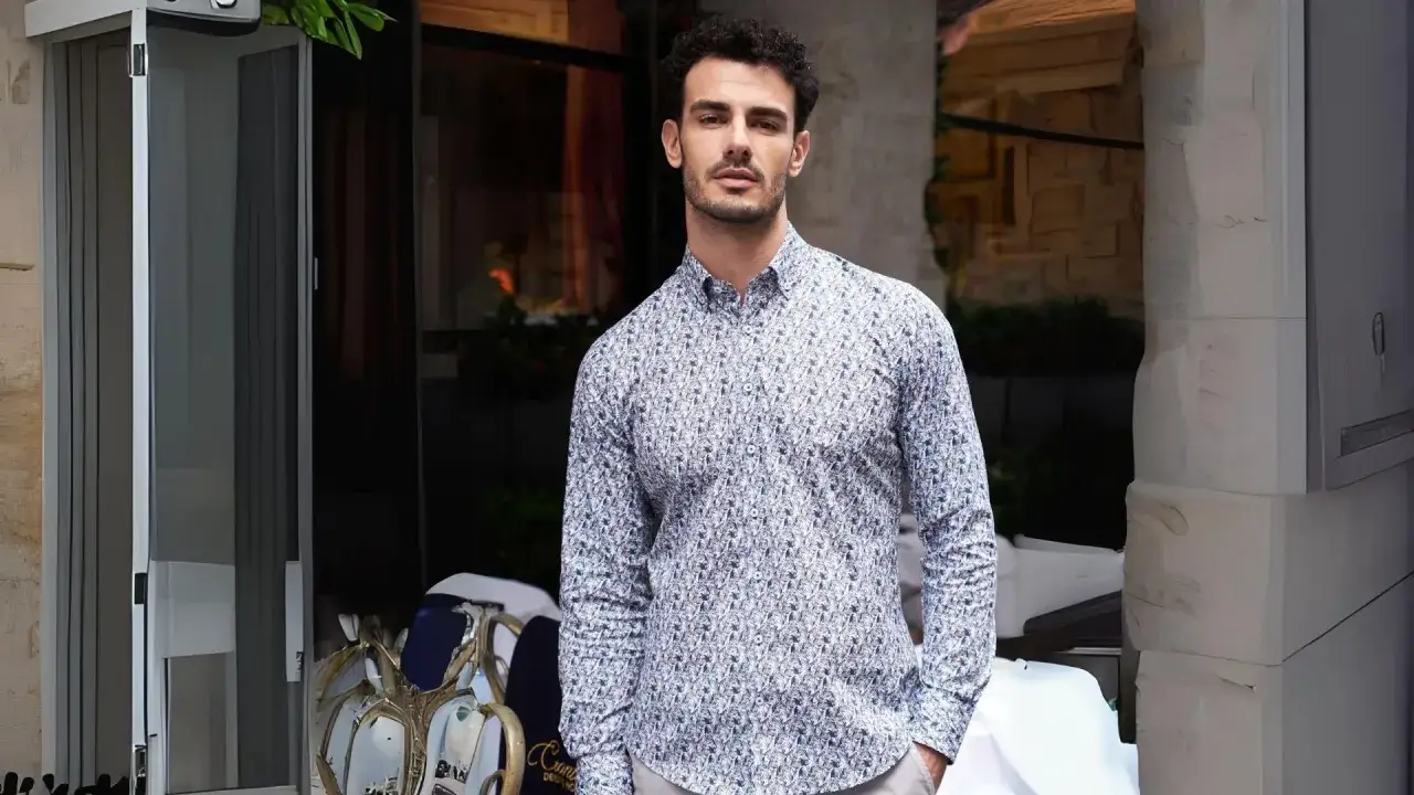 Uomo con camicia invernale a fantasia, con un look casual ma elegante, pronto per una passeggiata autunnale.