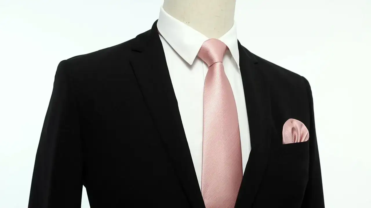 Elegante abbinamento cravatta rosa e pochette su giacca nera. Un tocco di colore raffinato per ogni occasione.