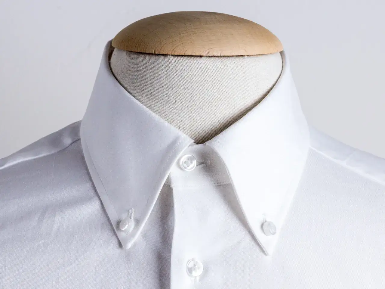 Collo di camicia bianca con botton down, pronto per essere indossato.