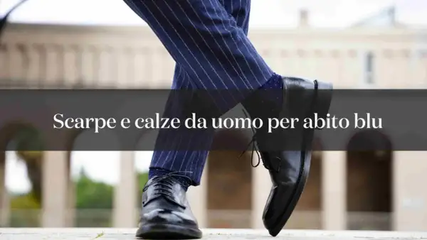 Eleganza maschile: abbinamento blu e grigio con calze a pois e scarpe stringate nere.