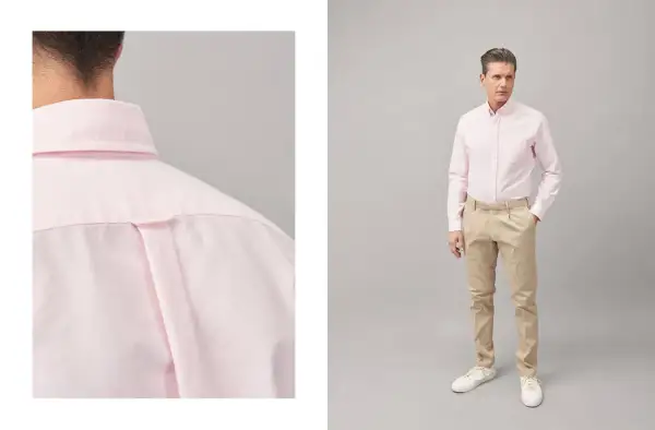 Uomo con abito blu e camicia rosa, un look elegante e moderno.