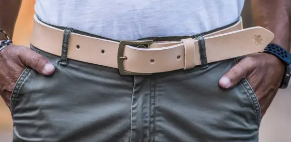 Uomo con cintura in cuoio chiaro, fibbia in ottone. La cintura si mette da che parte si desidera, ma solitamente a sinistra per comodità.