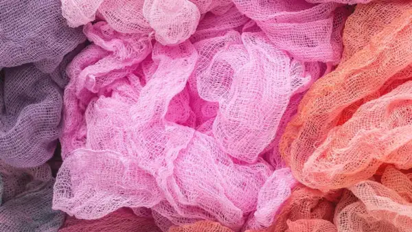 Tessuti morbidi e drappeggiati in tonalità pastello, dal lilla al rosa acceso fino all'arancio. Un'ispirazione per chi vuole imparare come decolorare un tessuto e creare sfumature uniche.